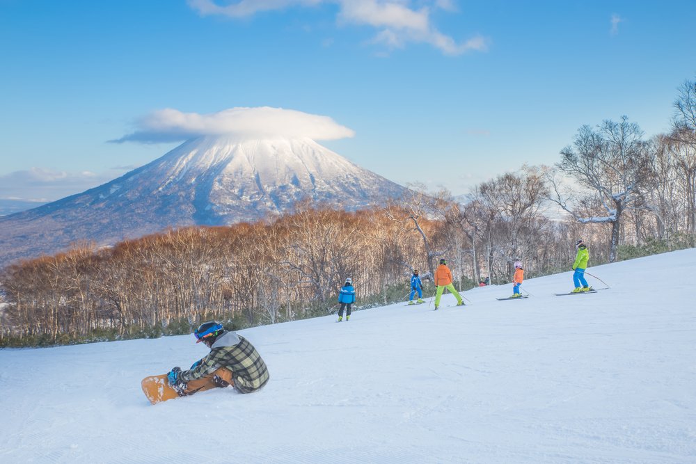 People skiing on the snow slope and Mt.Yotei as a background in Niseko Ski area, Hokkaido