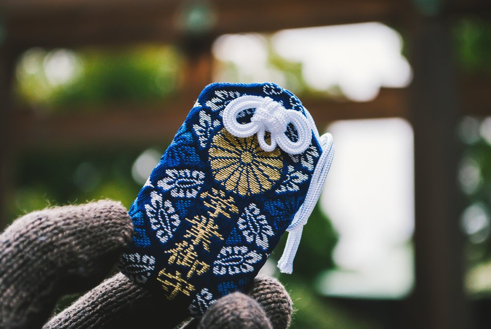 Omamori Japanese lucky charm holding in a hand in cloudy day